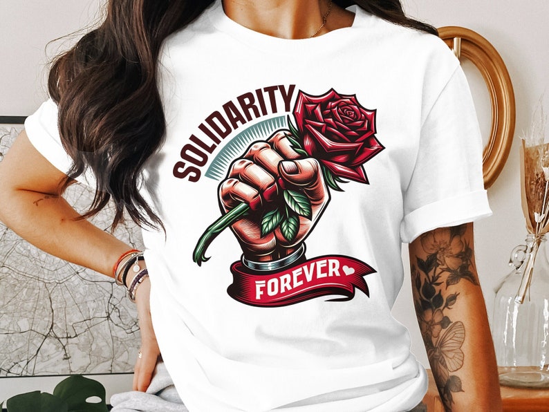 May include: White t-shirt with a graphic of a fist holding a red rose with the text "Solidarity Forever" and a small heart.