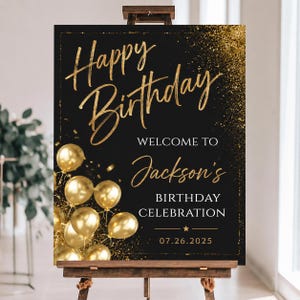May include: A black rectangular birthday sign featuring gold glitter accents and metallic gold balloons. The text reads: Happy Birthday, WELCOME TO Jackson's BIRTHDAY CELEBRATION, and the date 07.26.2025. The sign is displayed on a wooden easel stand.