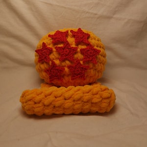May include: A yellow crocheted hat with seven red star embellishments. The hat is paired with a matching yellow crocheted headband.