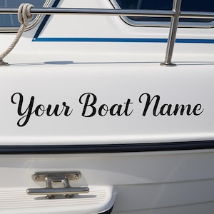 May include: White boat hull with the text "Your Boat Name" in black script. The boat has a stainless steel railing and a rope. A boat cleat is visible near the bottom of the image.