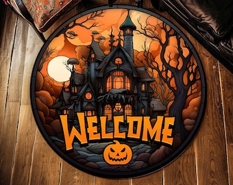 May include: Round Halloween welcome mat featuring a spooky haunted house scene with a full moon and bare trees. The word "WELCOME" is in orange, with a jack-o'-lantern below. The mat is on a wooden floor.