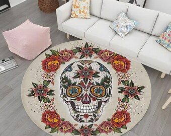 May include: A round rug with a white background and a colorful sugar skull design. The skull is surrounded by a wreath of red, pink, and green flowers.