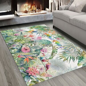 May include: A tropical-themed rug with a white background featuring colorful toucans, parrots, and flowers on lush green foliage.