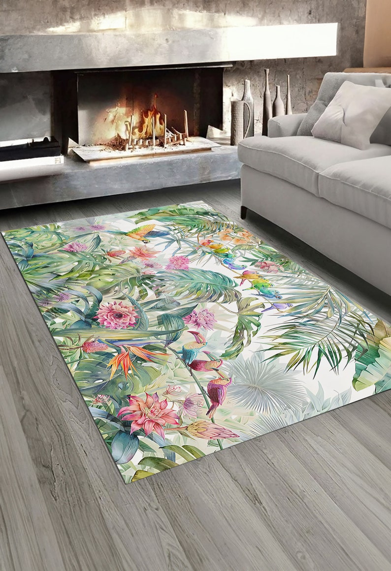 May include: A tropical-themed rug with a white background featuring colorful toucans, parrots, and flowers on lush green foliage.