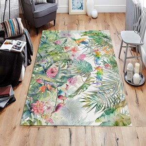 May include: A tropical-themed area rug with a white background featuring colorful toucans, parrots, and flowers. The rug has a green, white, and pink color scheme.