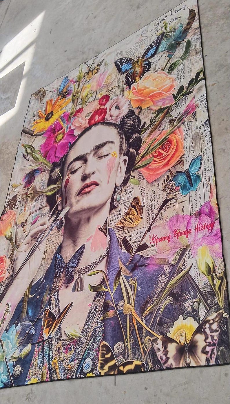 May include: A colorful art print featuring a portrait of a woman with closed eyes, adorned with a floral headdress and butterflies. The artwork incorporates elements of collage, with newspaper clippings and vibrant flowers. The color palette includes pinks, blues, and yellows.