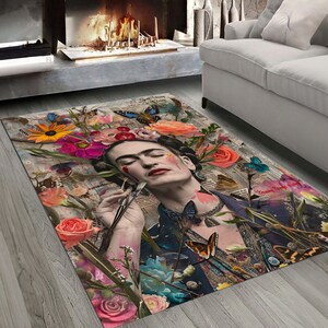 May include: Rectangular area rug featuring a collage of flowers, butterflies, and a portrait of a woman with a unibrow. The rug has a vintage aesthetic with a mix of floral and newspaper-style elements. The color palette includes pink, orange, blue, and green.