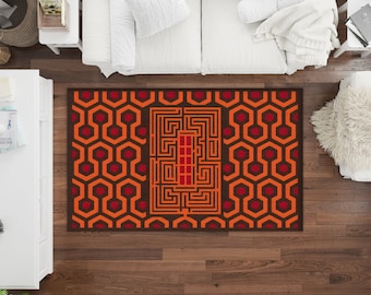 May include: A brown and orange area rug with a geometric pattern of hexagons and a maze design in the center. The rug has a red border.