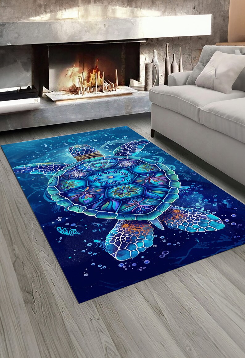 Op de afbeelding: Een blauw en paars gestreept tapijt met een groot zeeschildpad ontwerp. De schildpad heeft een gedetailleerd mandala-patroon op zijn schild en is omringd door bubbels.