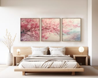 May include: Three framed prints of pink cherry blossoms in a bedroom setting. The prints are hung above a wooden bed frame with white bedding.