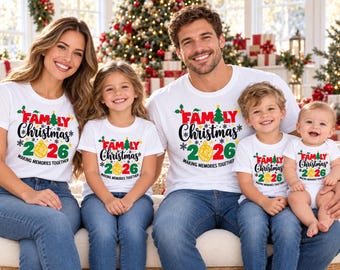 Könnte beinhalten: Weiße T-Shirts und ein Baby-Body mit einem festlichen Aufdruck mit dem Text "FAMILY CHRISTMAS 2026 MAKING MEMORIES TOGETHER" in Rot, Grün und Gelb, verziert mit einem Weihnachtsbaum, Stechpalmen und einem goldenen Ornament-Design.