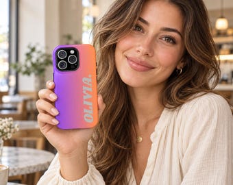 May include: A smartphone case featuring a vibrant purple to orange gradient color scheme. The name OLIVIA is printed vertically in bold white capital letters along the right side of the case. The case includes a cutout for a triple camera lens.