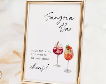May include: A white sign with gold trim that reads "Sangria Bar" in black cursive lettering. The sign also includes a watercolor illustration of two glasses of sangria with fruit and a cinnamon stick. The text below the illustration reads "Pour the wine, top with fruit, sip and enjoy, cheers!"