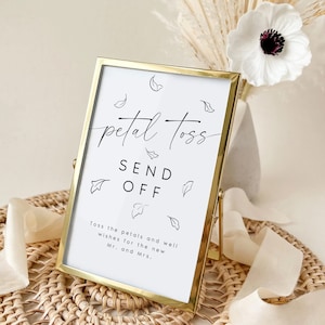 May include: A gold-framed sign with the text "petal toss send off" in black script. The sign also includes a small floral design and the text "Toss the petals and well wishes for the new Mr. and Mrs."