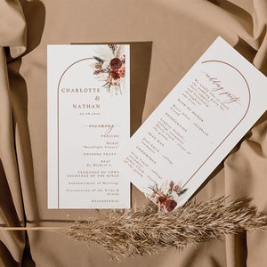 Puede incluir: Programa de ceremonia de boda con un diseño floral en tonos rojos, marrones y crema. El programa enumera el orden de los eventos, incluyendo el preludio, la oración de apertura y el intercambio de votos. El texto dice "Charlotte & Nathan".