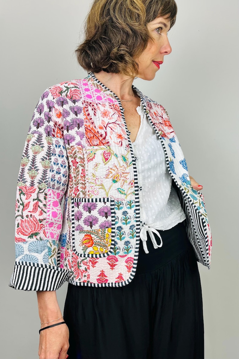 Pu&ograve; includere: Una giacca trapuntata patchwork colorata con stampa floreale. La giacca ha un colletto alla coreana, maniche lunghe e una cravatta in vita.
