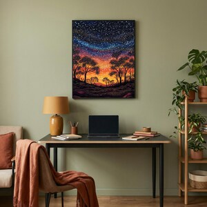 May include: A framed rectangular wall art print featuring a vibrant landscape painting of a starry night sky above a silhouette of trees and a glowing orange horizon, displayed in a home office setting with a desk, lamp, and laptop.