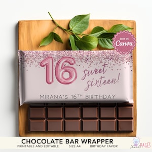 Puede incluir: Una barra de chocolate con un envoltorio rosa que presenta el texto "16 sweet sixteen!" y "Mirana's 16th Birthday". El envoltorio tiene un diseño de purpurina rosa y está colocado sobre una tabla de madera con hojas verdes.