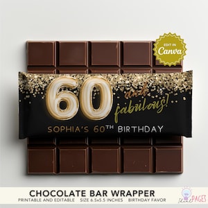 Puede incluir: Una barra de chocolate con un envoltorio negro con texto dorado y purpurina. El envoltorio dice "60 and fabulois!" y "Sophia's 60th Birthday." La barra mide 16.5 x 14 cm.