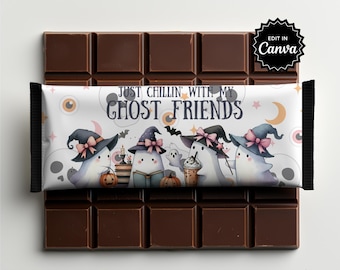 May include: A rectangular chocolate bar wrapper featuring the text JUST CHILLIN WITH MY GHOST FRIENDS. The design displays four white ghosts wearing witch hats with pink bows, pumpkins, a book, and a drink, set against a background of skulls.