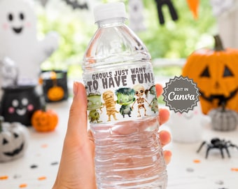 May include: A clear plastic water bottle featuring a white label with the text GHOULS JUST WANT TO HAVE FUN and colorful illustrations of a green monster, a mummy, a zombie, a skeleton, and a vampire. The label includes an EDIT IN Canva badge.