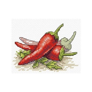 Può includere: Tre peperoncini rossi con steli e foglie verdi su uno sfondo marrone.