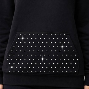 May include: Black hoodie with a white polka dot pattern on the front pocket. The hoodie is made of a soft material and has a classic design. A comfortable and stylish addition to any wardrobe.