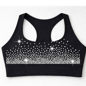 May include: Black sports bra with a racerback design. The bra is adorned with a pattern of white rhinestones, creating a sparkling effect. The design is concentrated at the bottom, fading upwards.