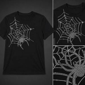 Könnte beinhalten: Schwarzes T-Shirt mit einem funkelnden Spinnen- und Netzdesign. Die Spinne und das Netz bestehen aus kleinen, glänzenden Verzierungen, die einen schillernden Effekt erzeugen. Das Design ist auf der Vorderseite des T-Shirts zentriert.