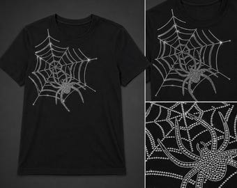 May include: Black t-shirt featuring a sparkling spider and web design. The spider and web are made of small, shiny embellishments, creating a dazzling effect. The design is centered on the front of the shirt.
