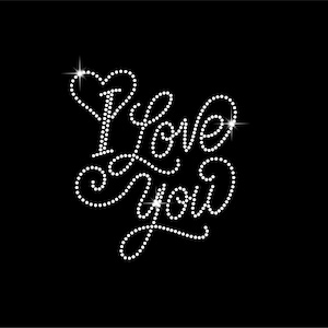 Könnte beinhalten: Schwarzer Hintergrund mit dem Satz "I Love You" in weißen, funkelnden Strasssteinen geschrieben. Das Wort "Love" ist kursiv geschrieben, und ein Herz befindet sich über dem Buchstaben "I".