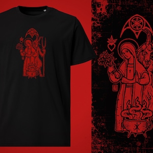 Puede incluir: Una camiseta negra con un estampado gráfico rojo de una mujer y una cabra de pie frente a un caldero. La mujer sostiene un ramo de flores y la cabra sostiene un tenedor.