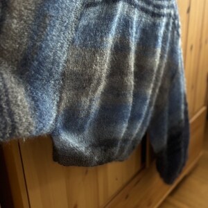May include: A blue and grey fuzzy knit sweater with a loose fit and long sleeves.