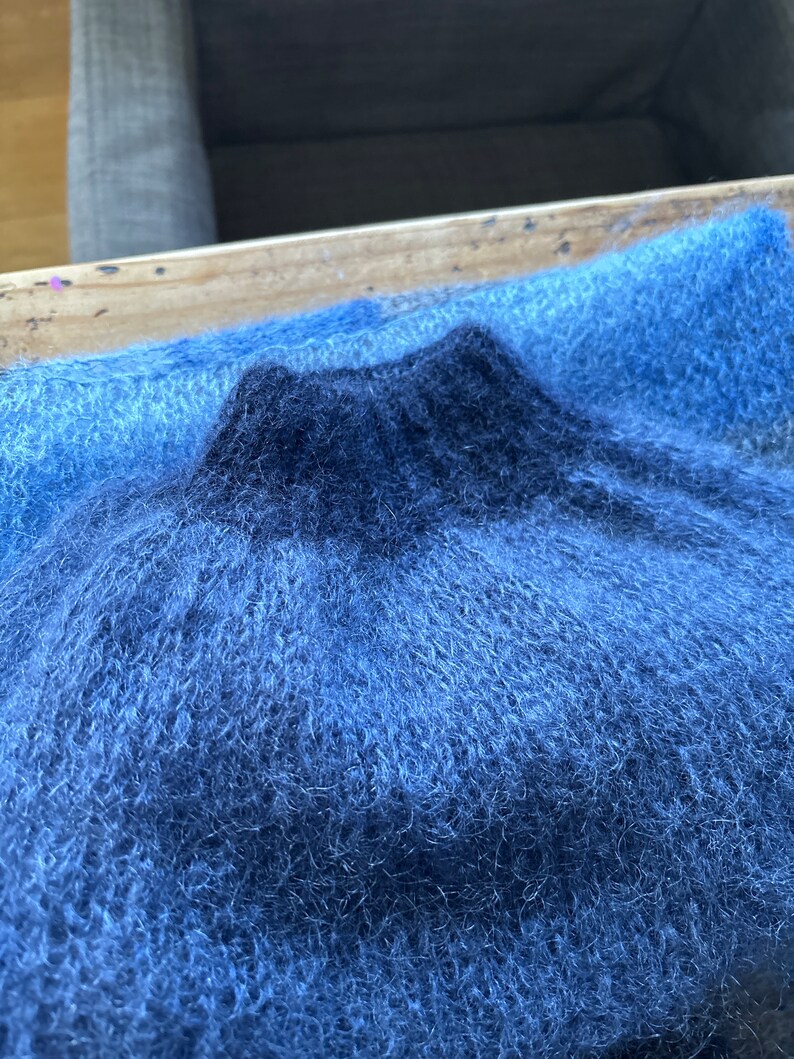 May include: A soft, blue and dark blue fuzzy fabric with a textured, fluffy surface.