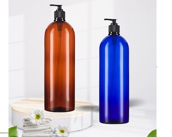 May include: Two plastic pump bottles, one brown and one blue, with black pump tops. The bottles are on a white wooden surface with a white towel and flowers.