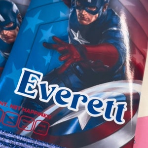 May include: A blue and red Captain America character is featured on a blue and white background with stars. The name Everett is written in blue letters on the bottom of the image. The image has a blue and white border.