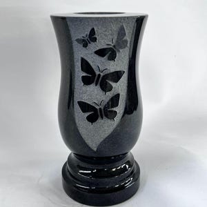 May include: A set of three ceramic mugs with a speckled, matte finish. The mugs are in shades of cream, light gray, and dark gray. Each mug has a simple, minimalist design and a rounded handle.
