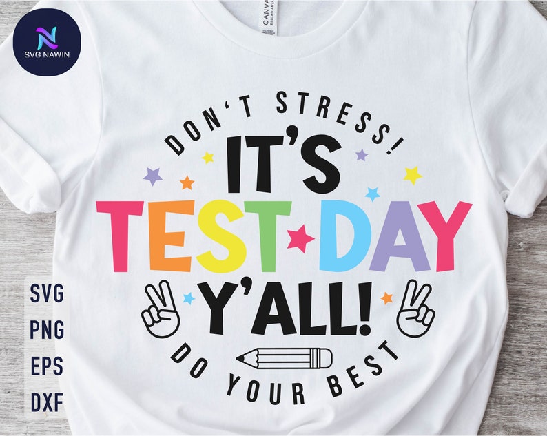 May include: White t-shirt with a colorful graphic that says "Don't Stress! It's Test Day Y'all! Do Your Best". The graphic includes stars, a pencil, and peace signs.