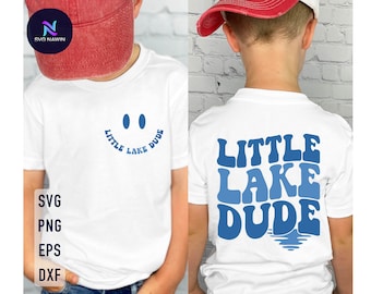 Puede incluir: Camiseta blanca con texto azul que dice "Little Lake Dude" con una carita sonriente encima del texto. La parte posterior de la camiseta tiene el mismo texto en una fuente más grande con una ola azul debajo.