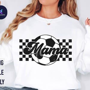 May include: White sweatshirt with a black and white checkered design and a soccer ball with the word "Mama" in a retro font.