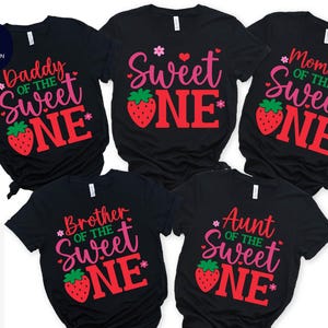May include: Five black t-shirts with a strawberry and text design. The shirts say "Daddy of the Sweet One", "Mommy of the Sweet One", "Brother of the Sweet One", "Aunt of the Sweet One", and "Sweet One".