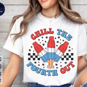 May include: White t-shirt with a red, white, and blue graphic design. The graphic features three popsicles with the text "Chill the Fourth Out" in a retro font.