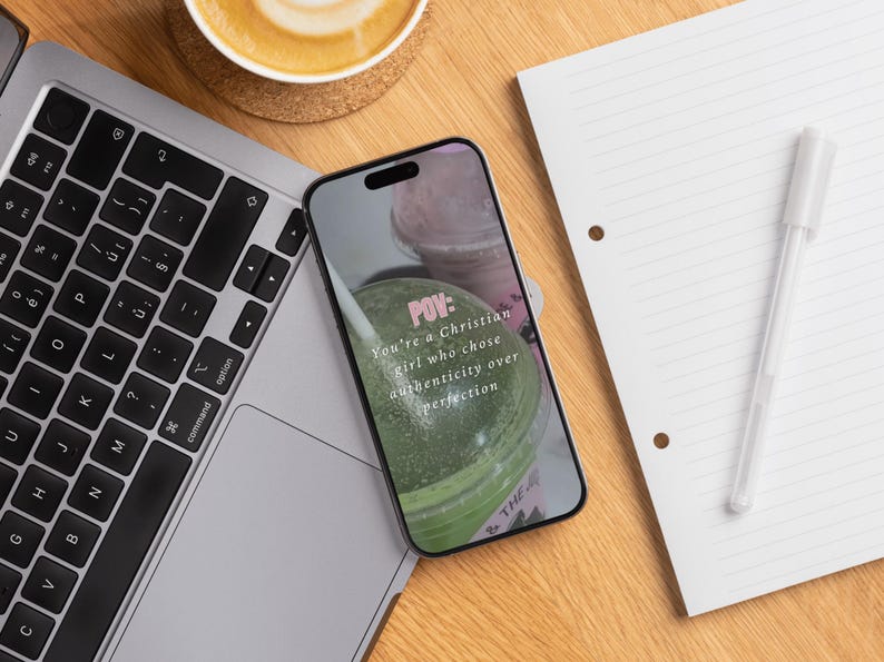 May include: A laptop, smartphone, coffee cup, notepad, and pen are arranged on a wooden surface. The smartphone displays text: "POV: You're a Christian girl who chose authenticity over perfection."