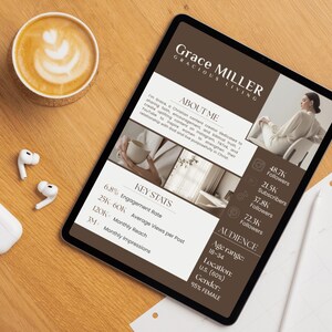 May include: A digital tablet displaying a media kit for Grace Miller Gracious Living, featuring an about me section, key stats, audience demographics, and social media follower counts, alongside white wireless earbuds and a cup of coffee.