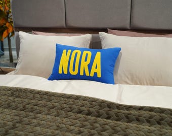 Almofada personalizada com nome bordado à mão (pun needle), capa de algodão.