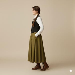 May include: A woman wearing a black vest over a white button-down shirt, paired with an olive green maxi skirt and brown leather boots. The outfit has a classic, timeless style, suitable for various occasions.