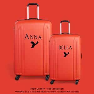 Peut inclure: Deux valises orange avec des poign&eacute;es et des roulettes noires. La plus grande valise porte le nom "ANNA" et un motif de queue de sir&egrave;ne. La plus petite valise porte le nom "BELLA" et un motif de queue de sir&egrave;ne.