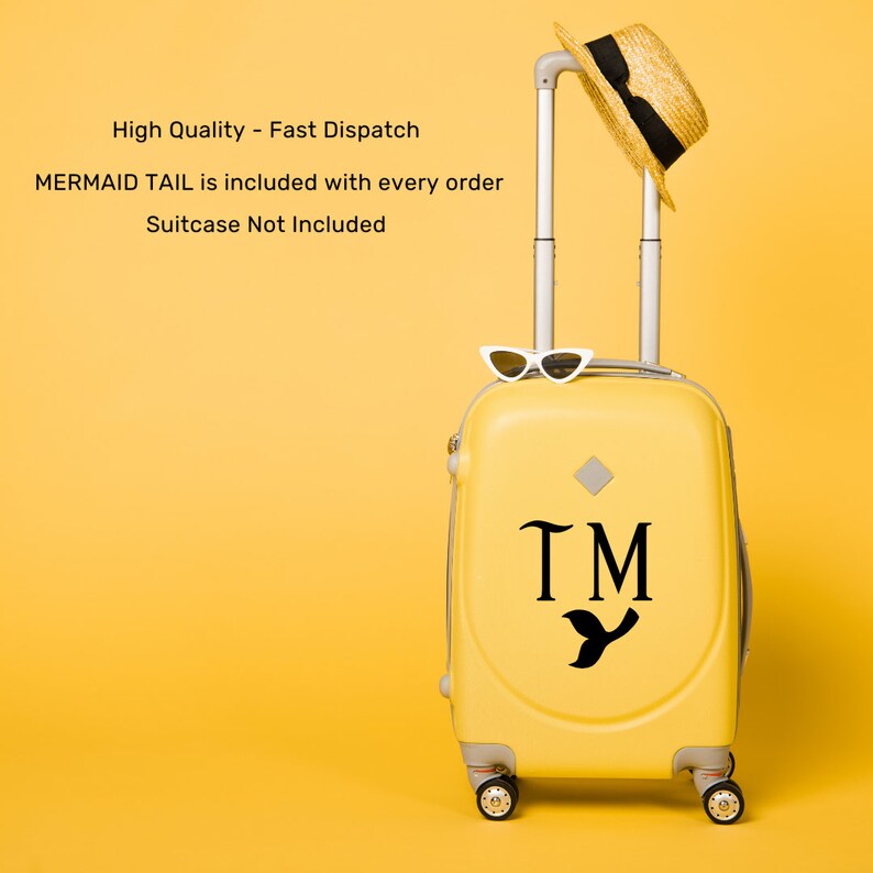 Peut inclure: Valise jaune avec une queue de sir&egrave;ne et les initiales "TM" sur le devant. La valise est sur un fond jaune.