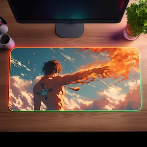 May include: A large, colourful mouse mat with a fiery orange and yellow design. A muscular figure with a skull and crossbones tattoo on their back stands against a blue sky with white clouds. The mouse mat has a red, green and yellow border.