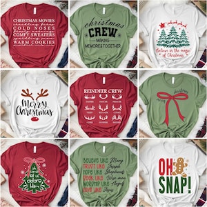 May include: A selection of Christmas-themed t-shirts in various colours, each with festive designs and text. Designs include phrases like "Christmas Movies," "Christmas Crew," and "Merry Christmas," along with reindeer and gingerbread man graphics.